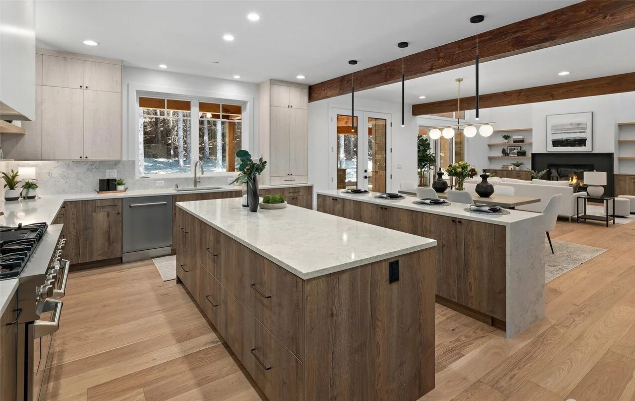 Completed open-plan kitchen with wood cabinetry and pale stone counters